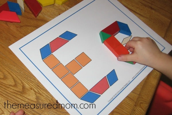child building the letter E with blocks