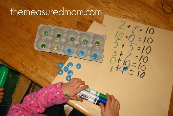 child practicing counting with gems