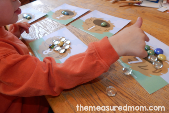 child placing gems on counting mat
