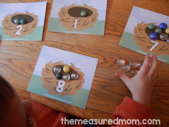 child placing gems on counting mat
