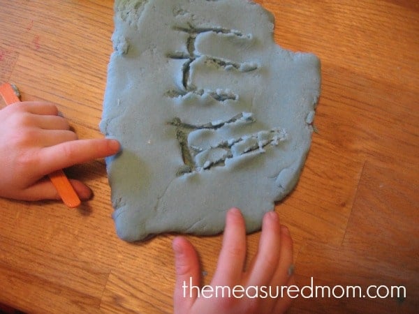 letter E written in playdough