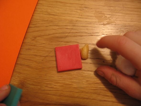 child comparing tile to shelled peanut