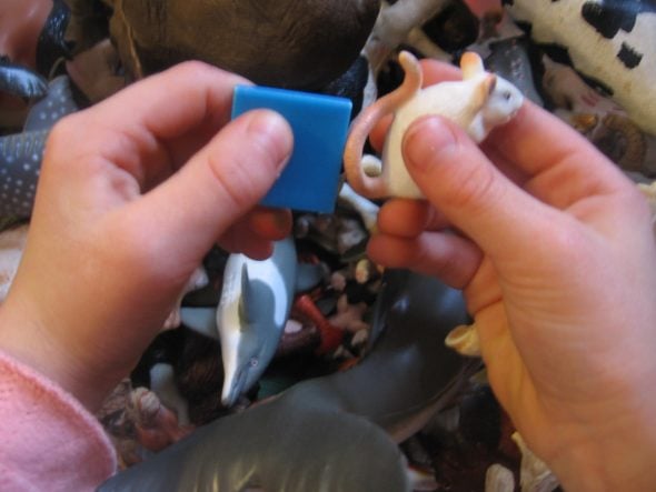 child holding tile and toy mouse
