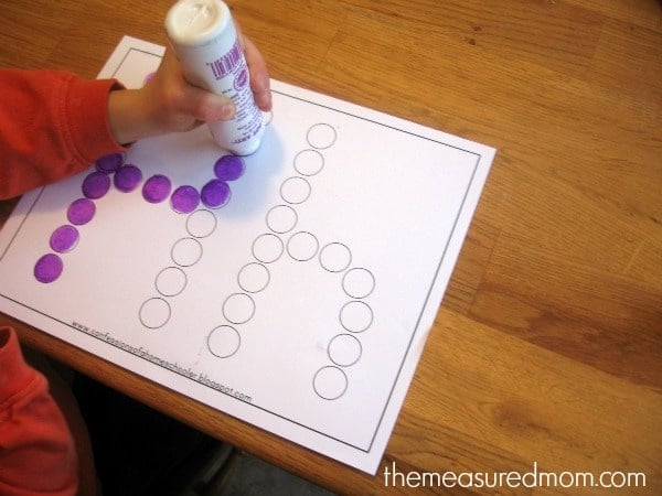 child putting dots on letter H worksheet