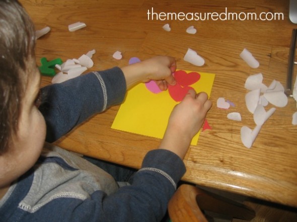 child placing heart stickers on paper