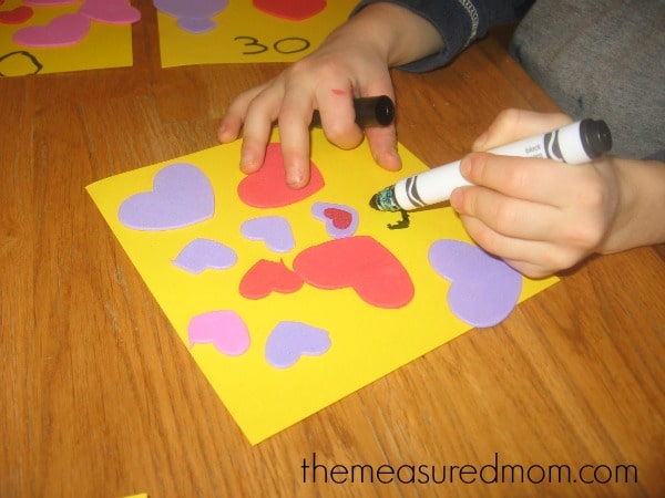 child writing number on paper