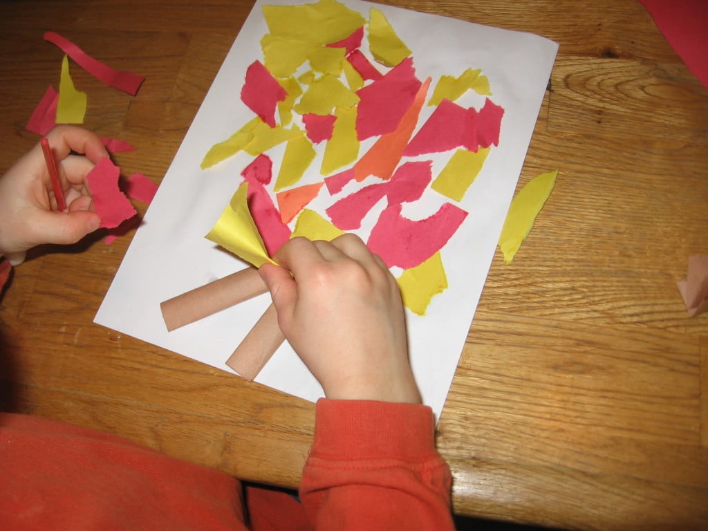 child placing colored paper on paper