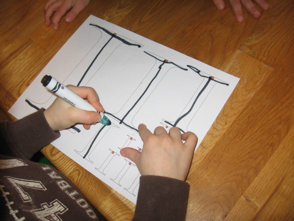 child writing I's on letter I worksheet