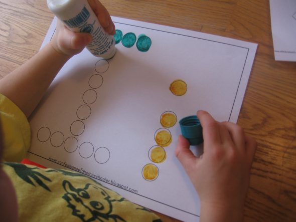 child stamping Do-A-Dot marker on letter I worksheet