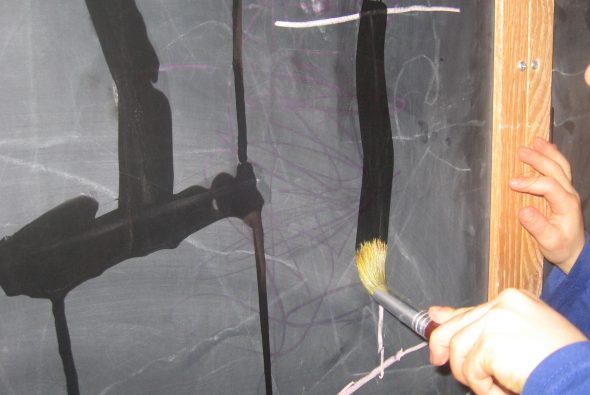 letter I written on chalkboard with water