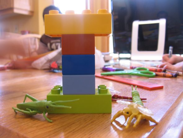 letter I made out of Duplos with toy insects