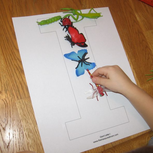 letter I formed from toy insects