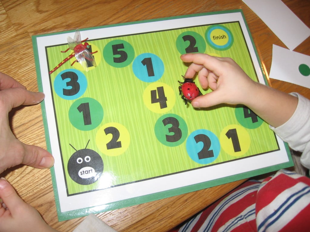 child placing toy bug on counting mat