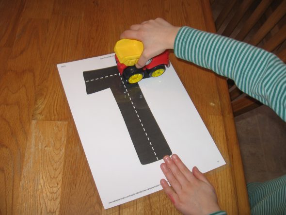 child with highway ABC card (letter T)