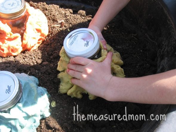 forming playdough around jar
