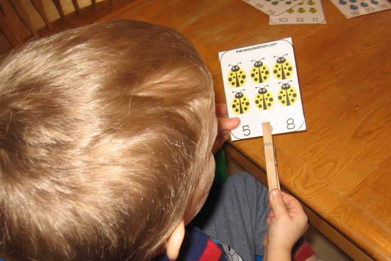 child clipping ladybug card
