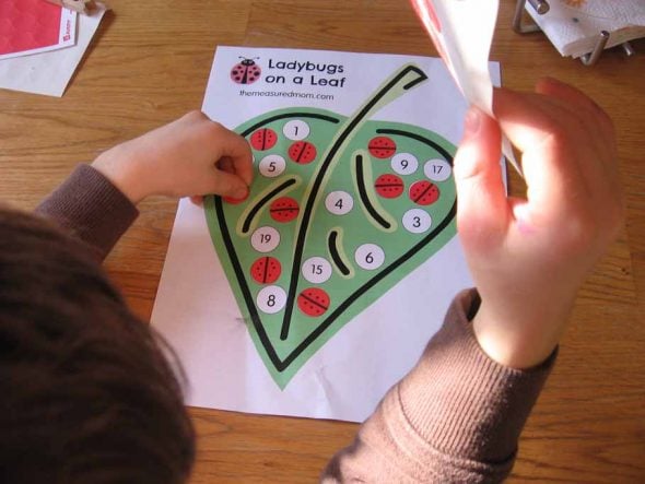 child placing sticker on clip art of leaf