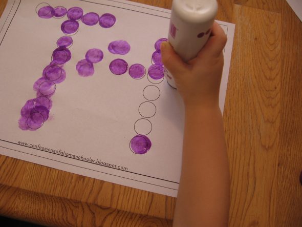 child stamping Do-A-Dot marker on letter T worksheet