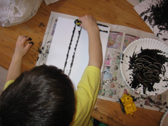 child making letter T with tire tracks