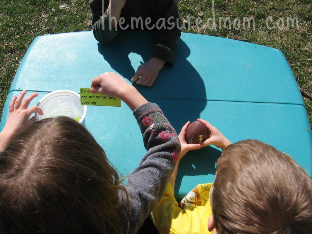 children around table with child holding card