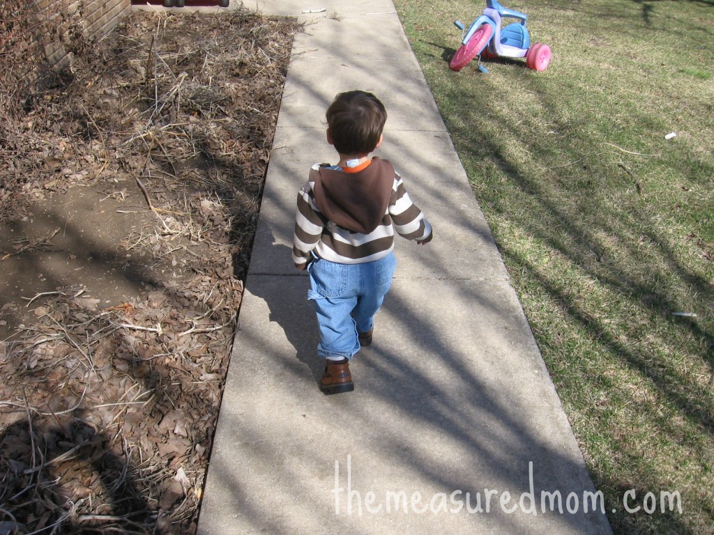 child walking on sidewalk