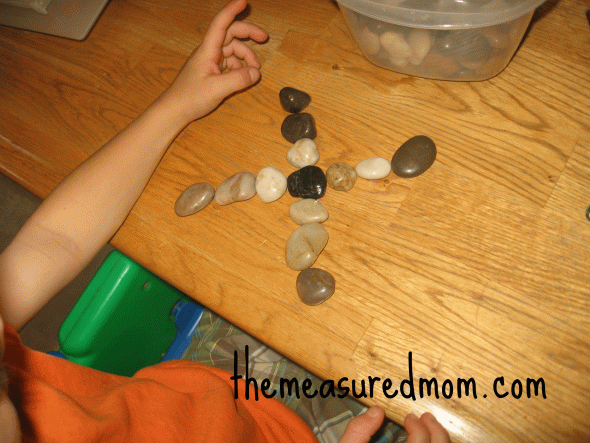 child with letter X with stones