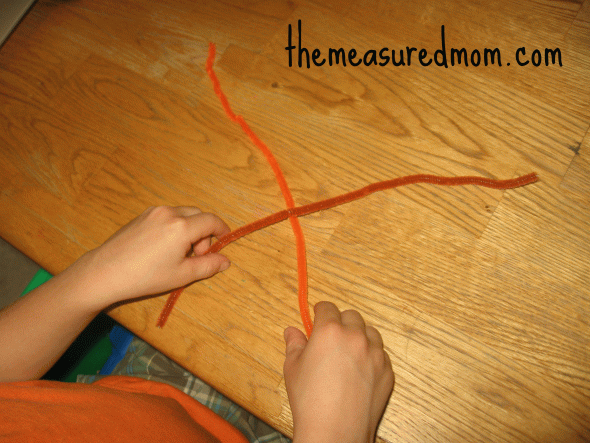 child making letter X with pipe cleaners