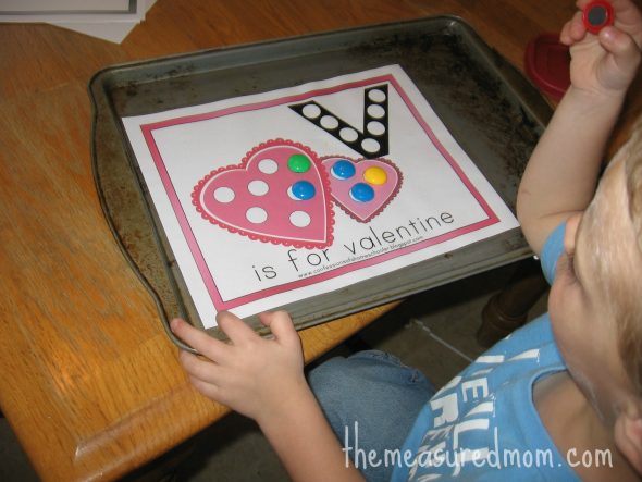 child placing magnets on V is for valentine worksheet