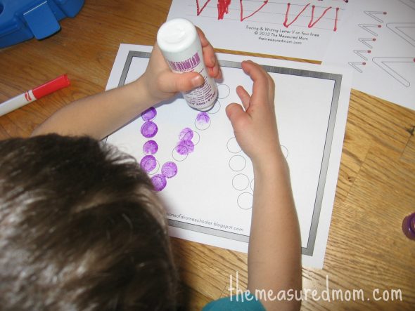 child stamping Do-a-Dot marker on V worksheet