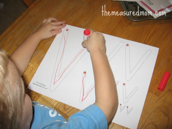 child writing on V worksheet