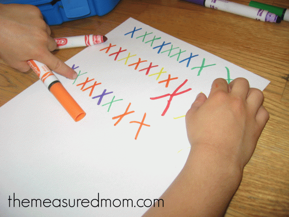 child finishing the X pattern letter X