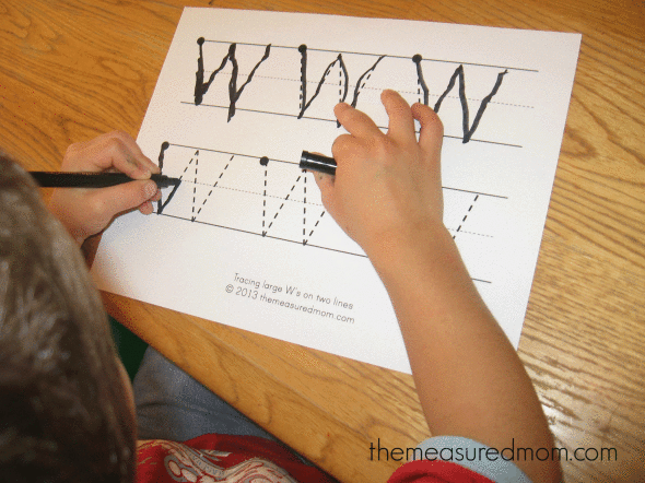 child writing on letter W worksheet