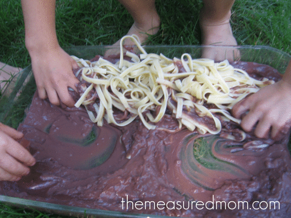 children playing with linguine and chocolate pudding