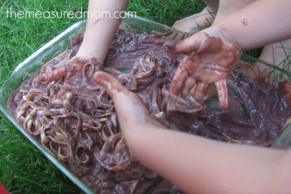 children playing with linguine and chocolate pudding