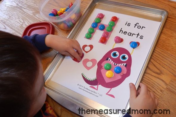 child placing magnets on letter H worksheet