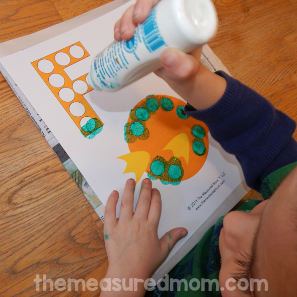 child stamping do-a-dot marker on letter F worksheet