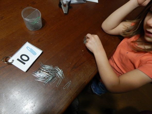 child counting paper clips