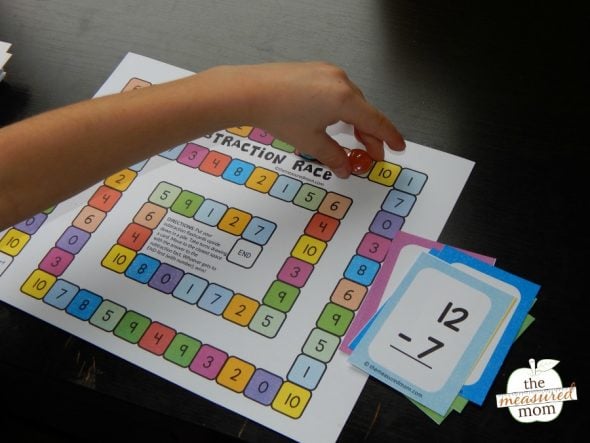 This simple subtraction activity will help kids in kindergarten and first grade practice their basic facts. The game includes free subtraction flash cards, too! #subtraction #kindergarten #mathfacts #subtractiongame child playing subtraction game